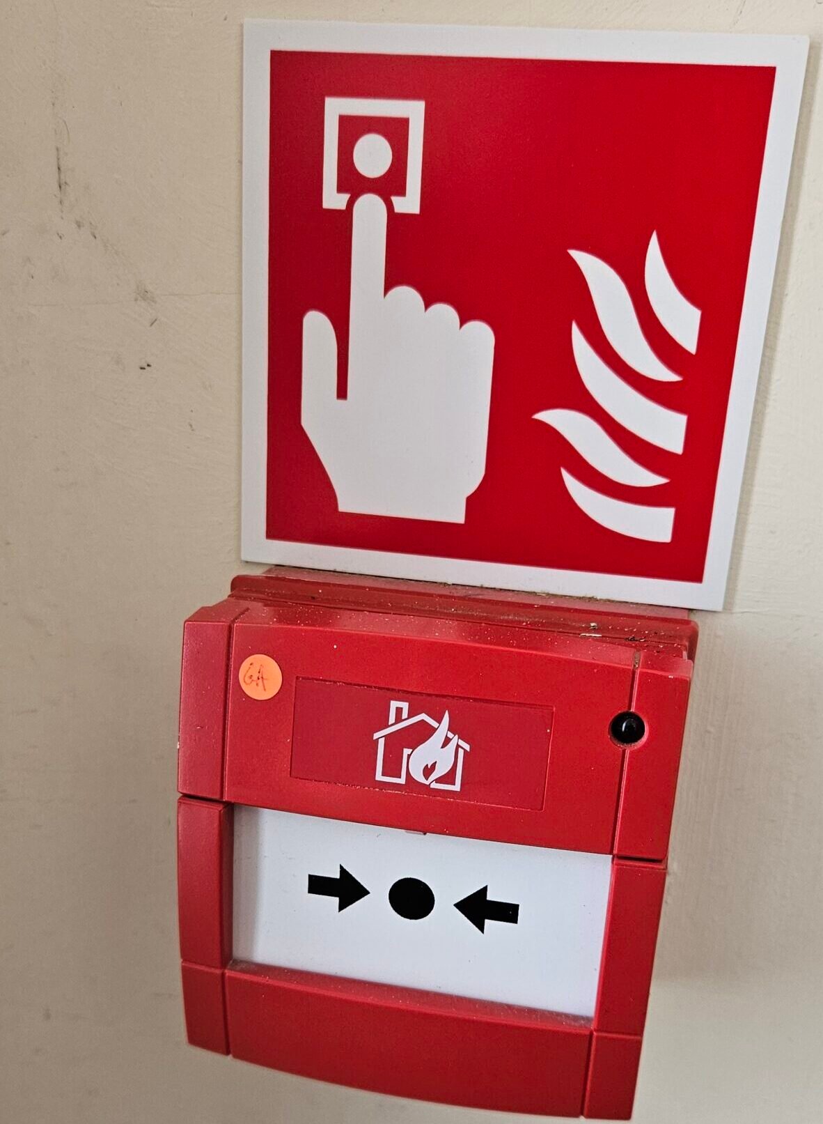 HOME SECURITY INSTALLATIONS | A red fire alarm call point on a wall.