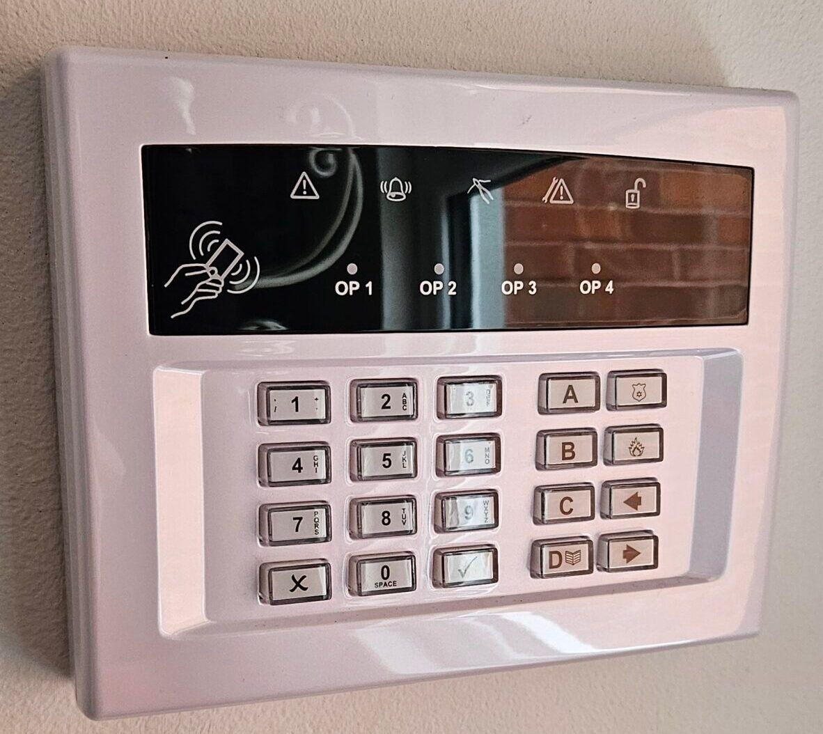 HOME SECURITY INSTALLATIONS | A modern white keypad for a home security alarm system.